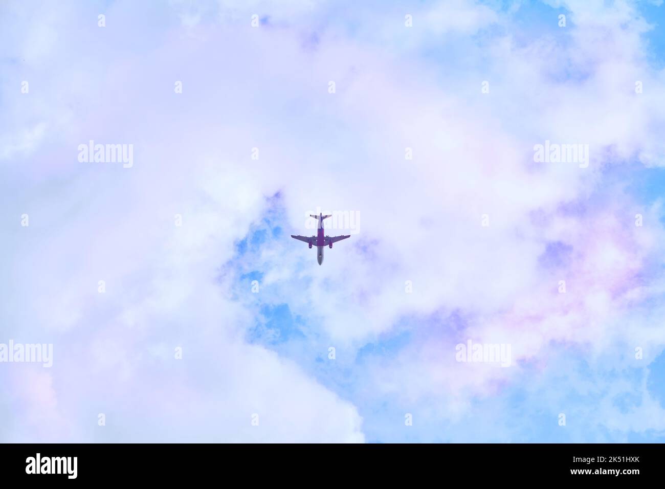 Red passenger plane in blue sky with pink clouds Stock Photo - Alamy
