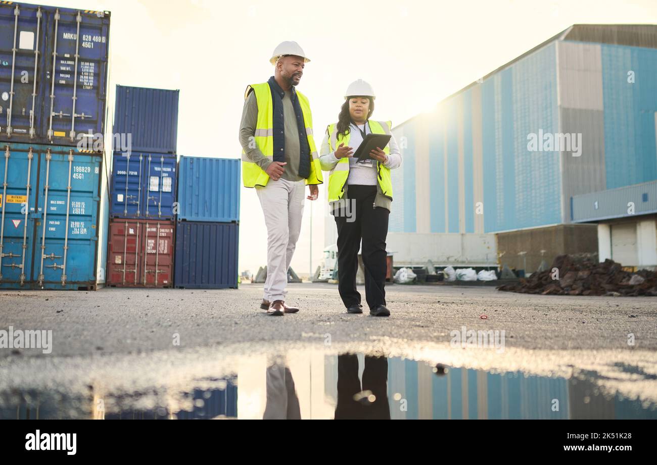Logistics, digital tablet and industrial employees working on an outdoor cargo freight delivery site. Supply chain, collaboration and black people Stock Photo
