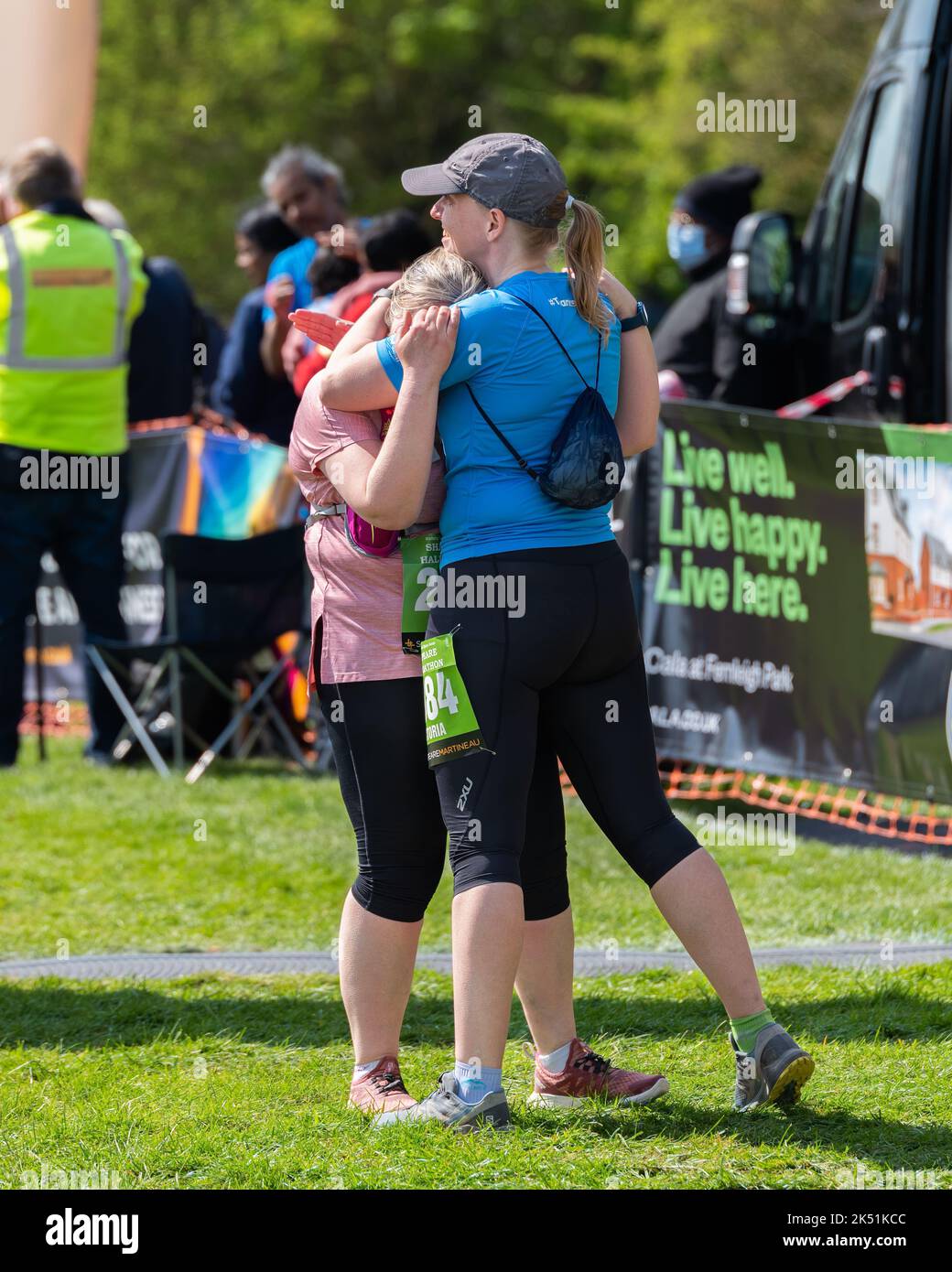 Shakespeare Marathon and half Marathon. Two women runners hugging in celebration of completing a race. Stock Photo