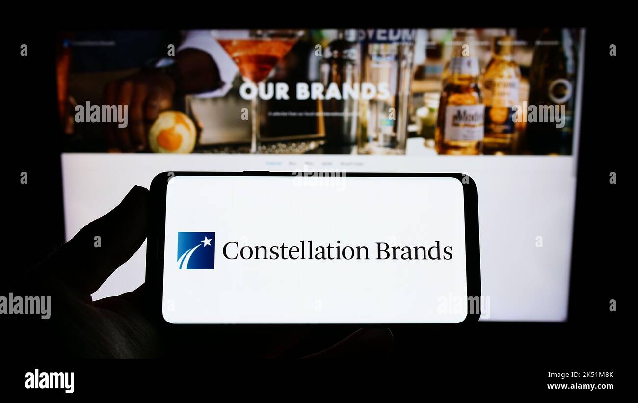 Person holding smartphone with logo of US beverage company