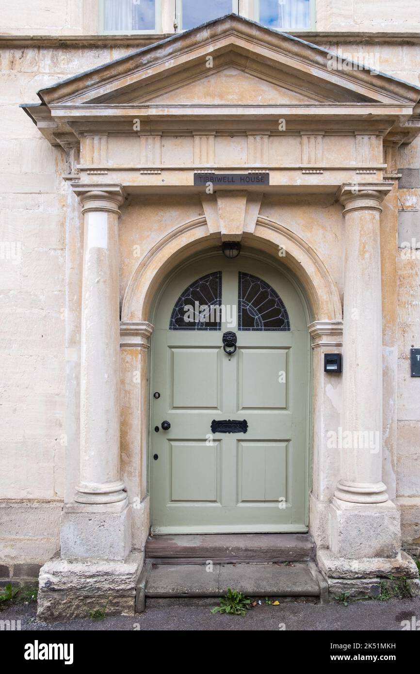Traditional wooden front door in an arched doorway in a Cotswold stone