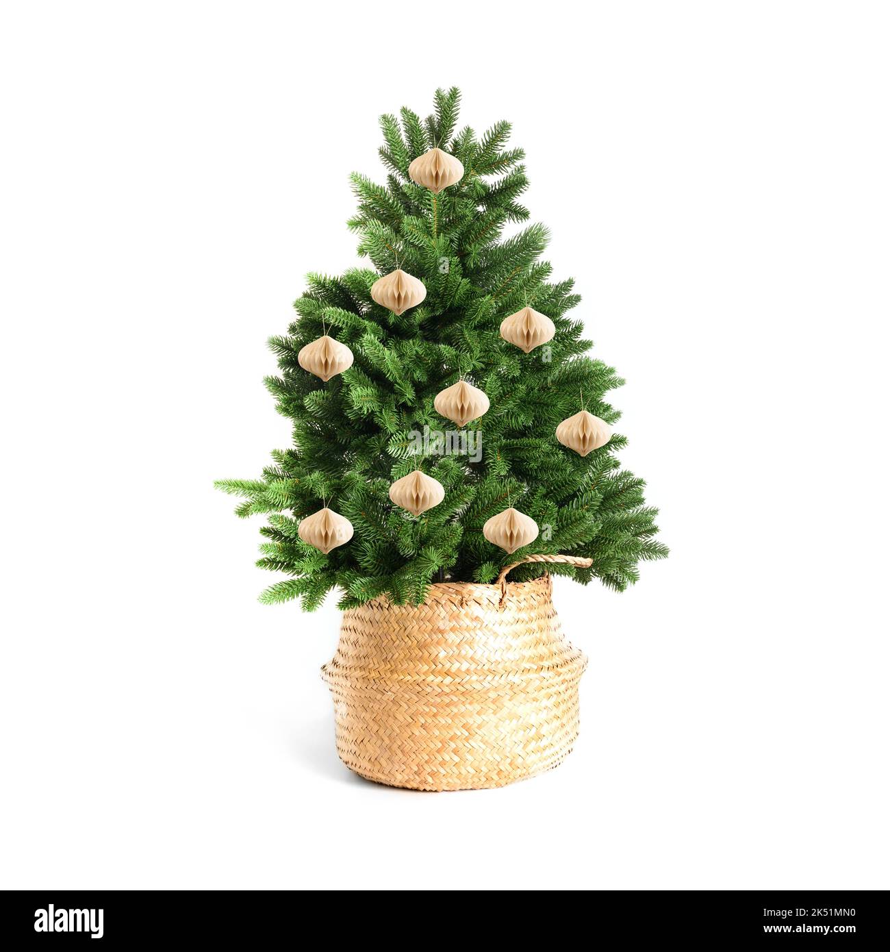 Christmas tree in wicker basket with white paper decorative balls