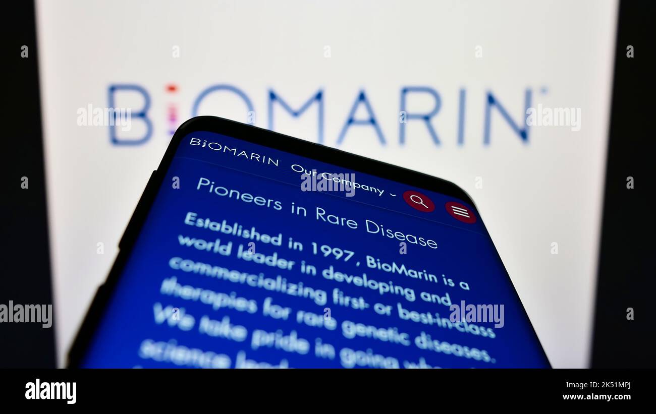 Smartphone with website of US company BioMarin Pharmaceutical Inc. on screen in front of business logo. Focus on top-left of phone display. Stock Photo