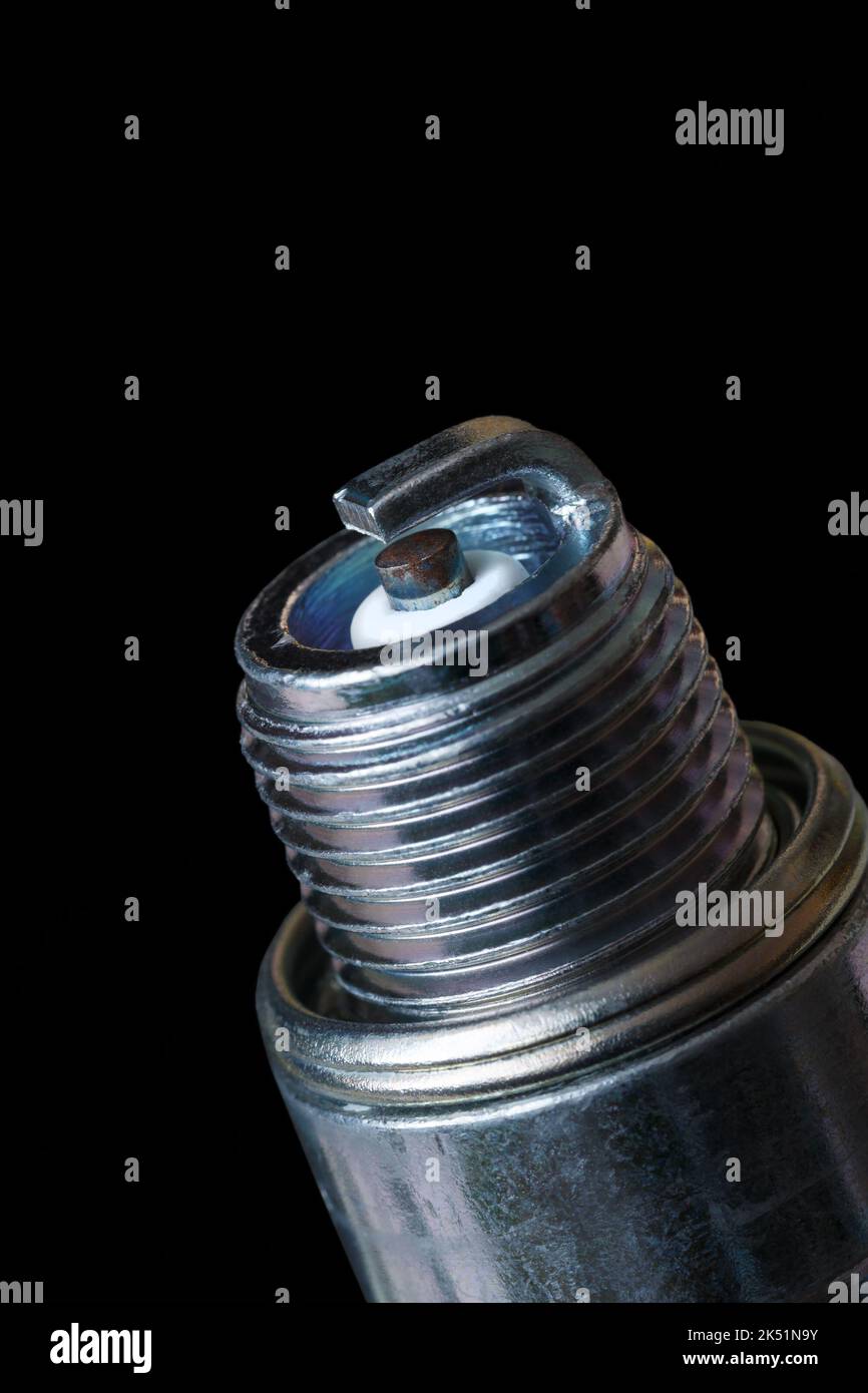 Classic spark plug with one electrode on a dark background. Close-up. Stock Photo