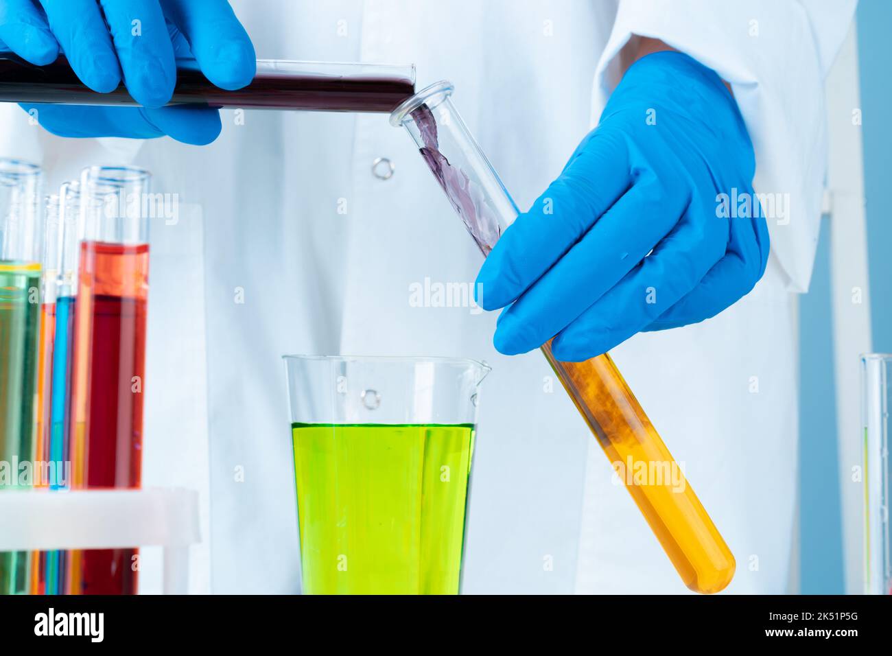 Manipulations with laboratory glass chemical containers on table Stock