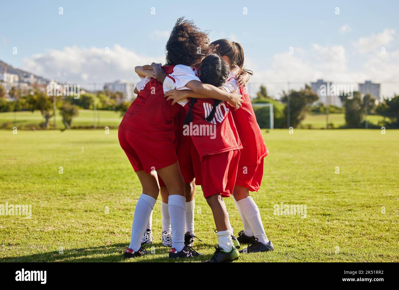 Children, football team and huddle of sports group together on soccer field for celebration of goal, winning and teamwork during a competition match Stock Photo