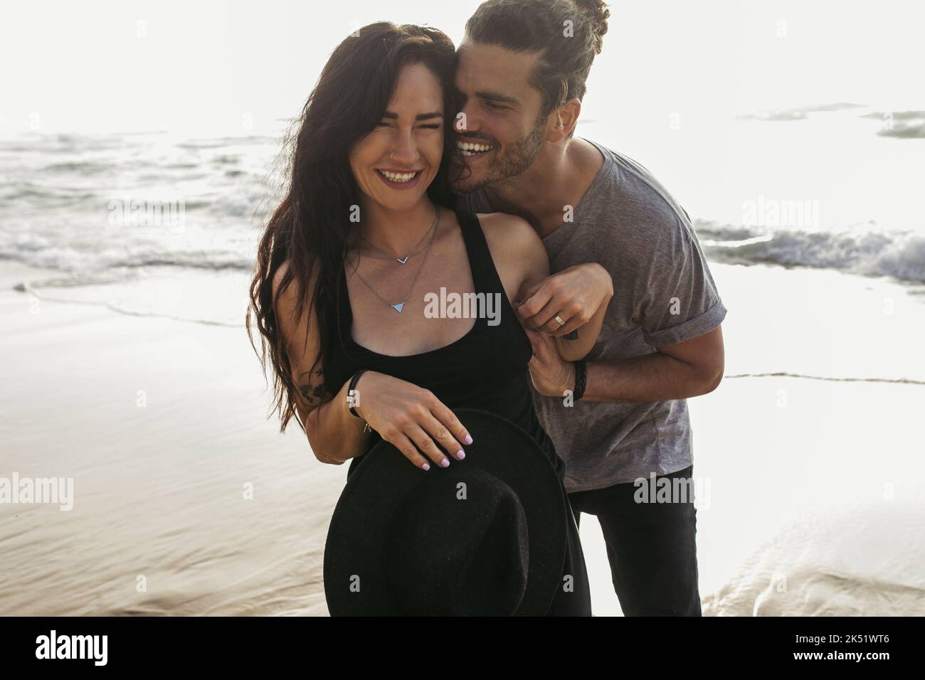 cheerful man tickling joyful girlfriend in dress near ocean in portugal,stock image Stock Photo