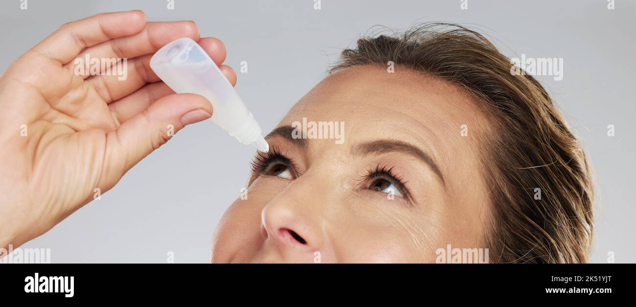 Woman with eye drops, healthcare and medicine in medical treatment. Tired eyes, glaucoma and allergy relief with zoom and macro shot of mature woman Stock Photo