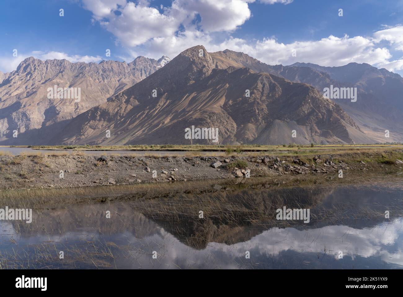 Landscape view of mountains in Afghanistan in the Panj river valley with reflection in water, Rushan, Gorno-Badakshan, Tadjikistan Stock Photo