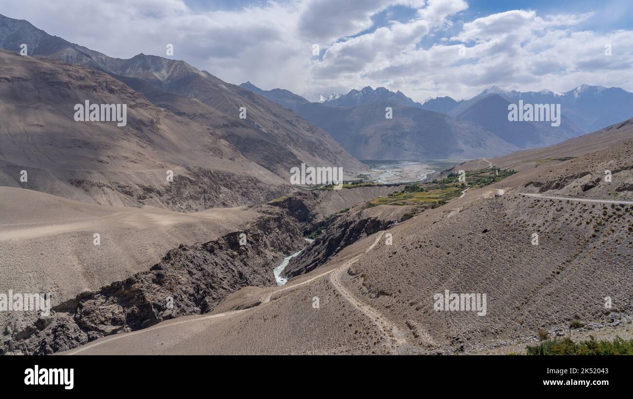 Landscape panorama of Pamir river gorge in high altitude desert bordering Afghanistan with Hindu Kush mountain range, Wakhan Corridor,  Tajikistan Stock Photo