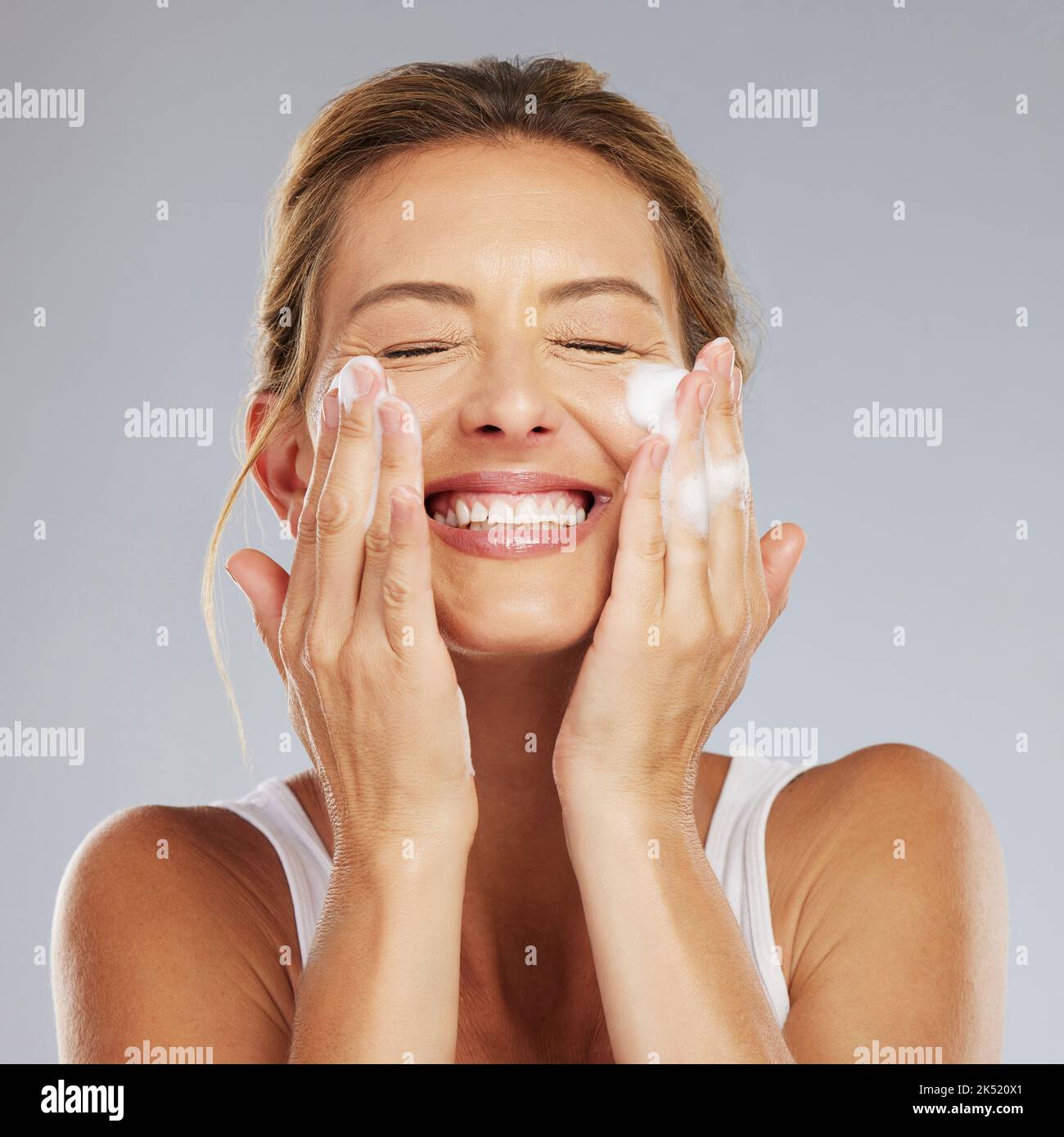 Face, cleaning and hygiene with a mature woman washing her skin in