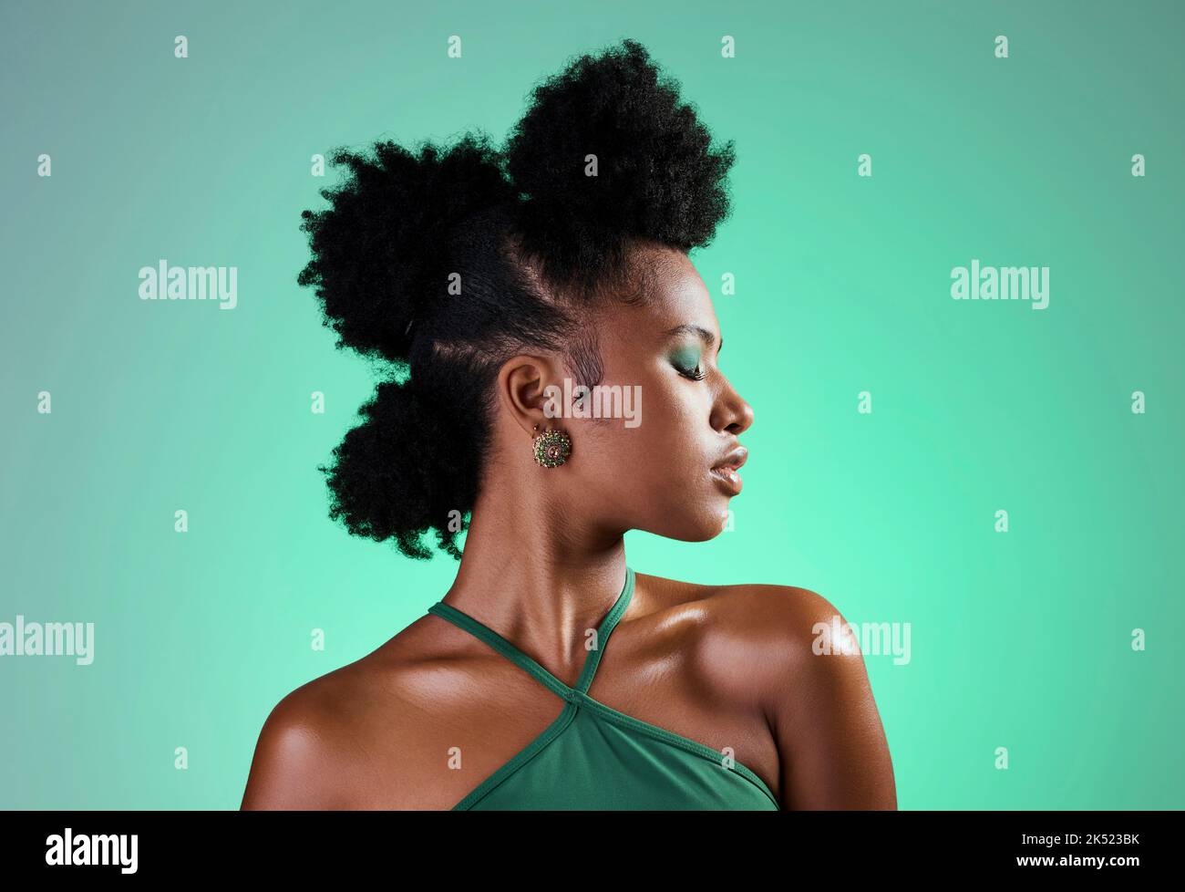 Black woman, green makeup and face on skin for beauty, fashion and cosmetics against backdrop. Model, girl and hair, show afro, eyeshadow and lips in Stock Photo