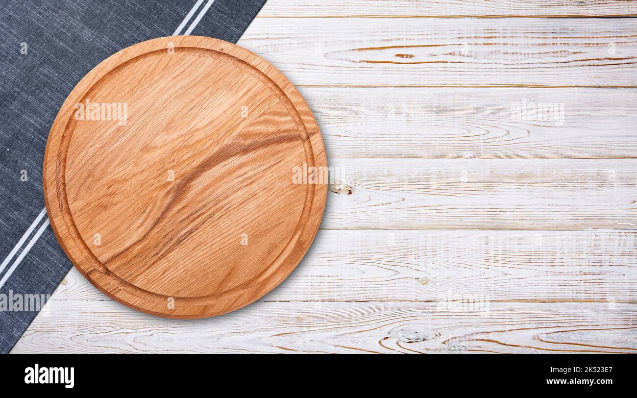 Pizza board with a napkin on white wooden table. Top view mock up Stock Photo