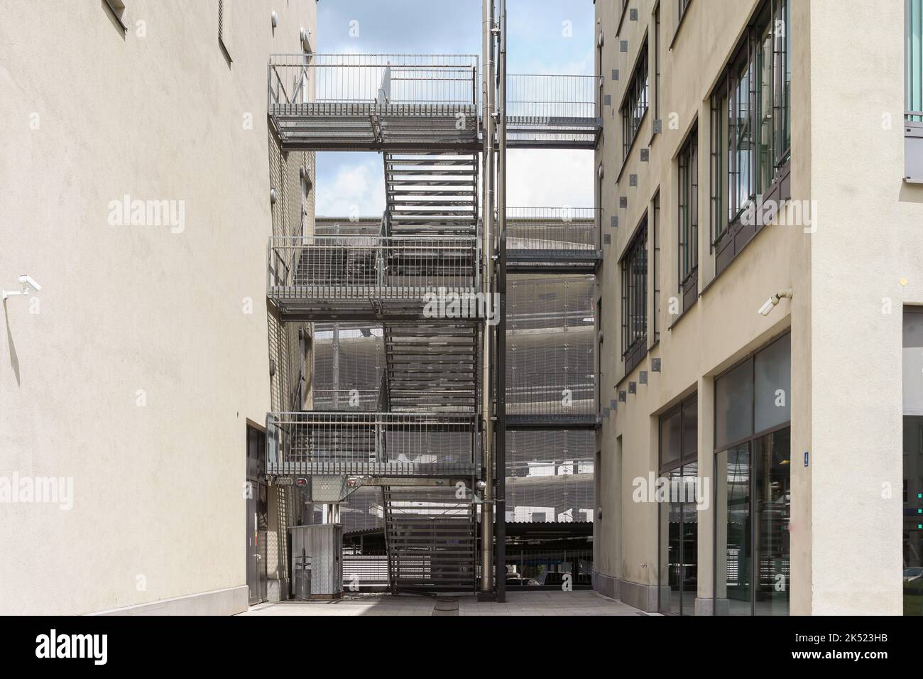 Outdoor stairs between two houses at a parking garage with stores - landscape format Stock Photo