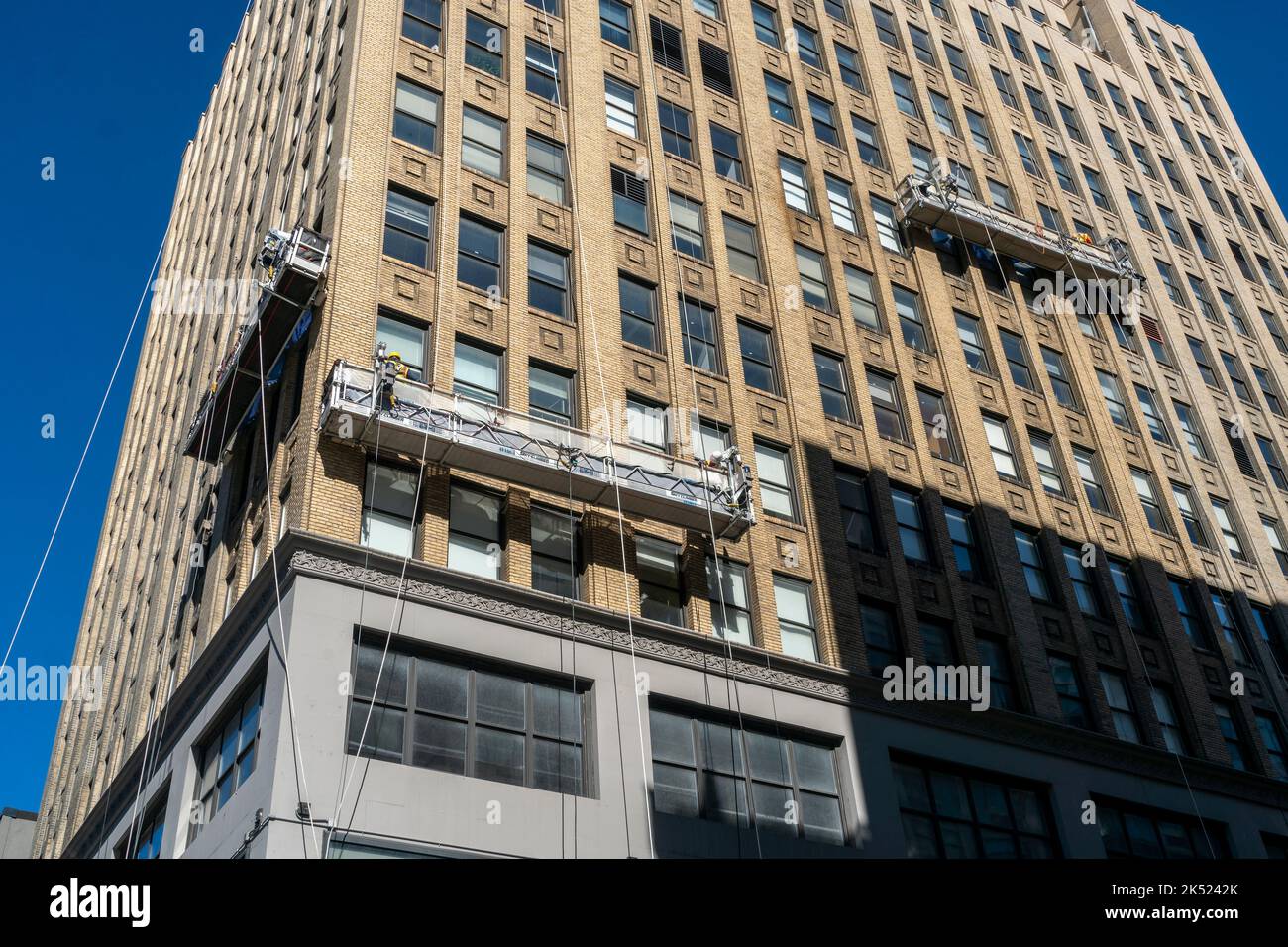 Workers suspended on scaffolds on an office building in the Chelsea neighborhood of New York on Friday, September 23, 2022.  (© Richard B. Levine) Stock Photo