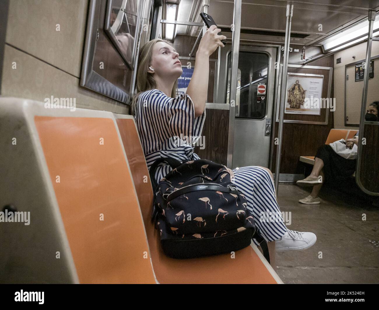 Woman inspects her face after applying make up on the subway in New York on Wednesday, September 28, 2022.  (© Richard B. Levine) Stock Photo
