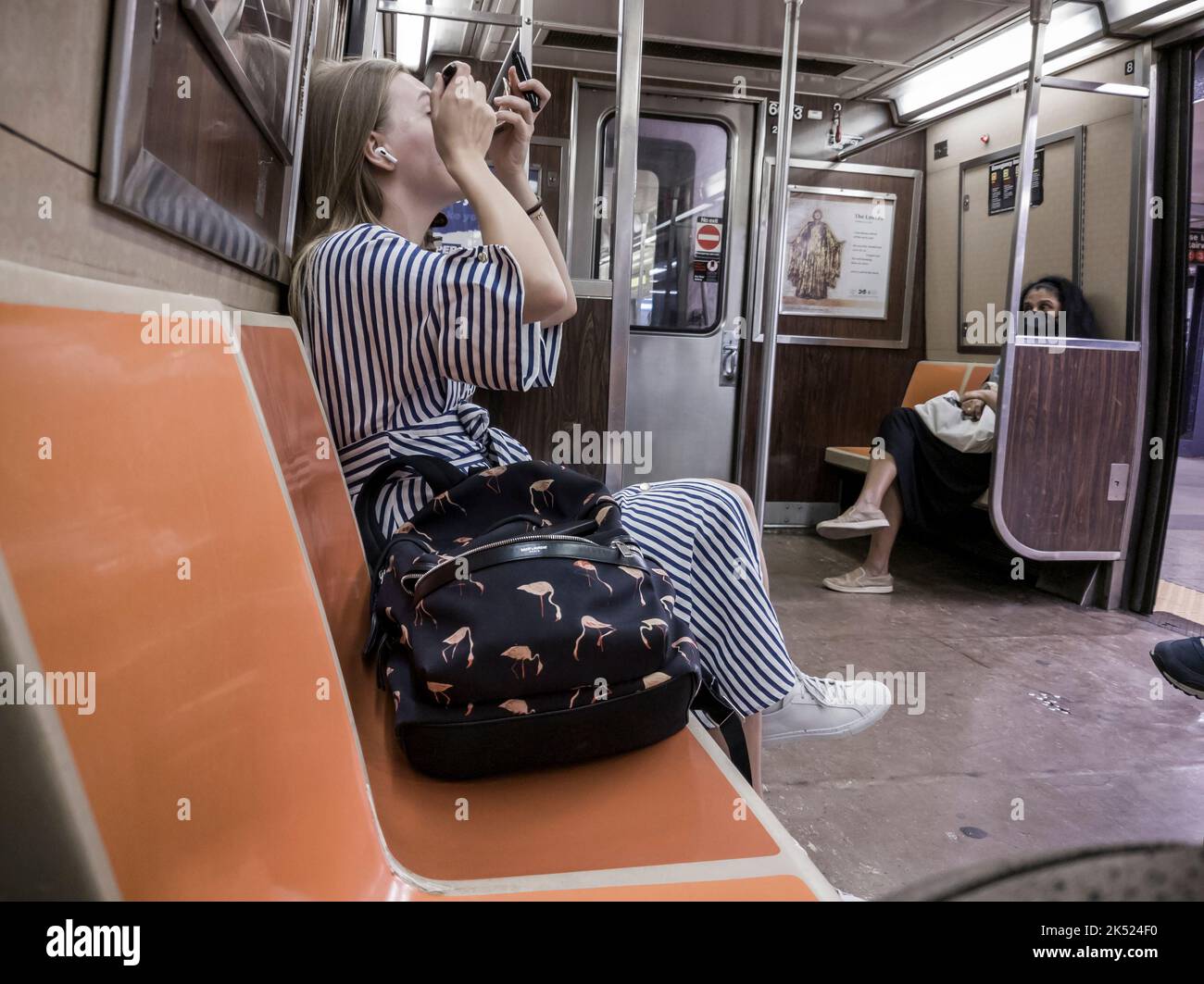 Woman busies herself applying make up on the subway in New York on Wednesday, September 28, 2022.  (© Richard B. Levine) Stock Photo