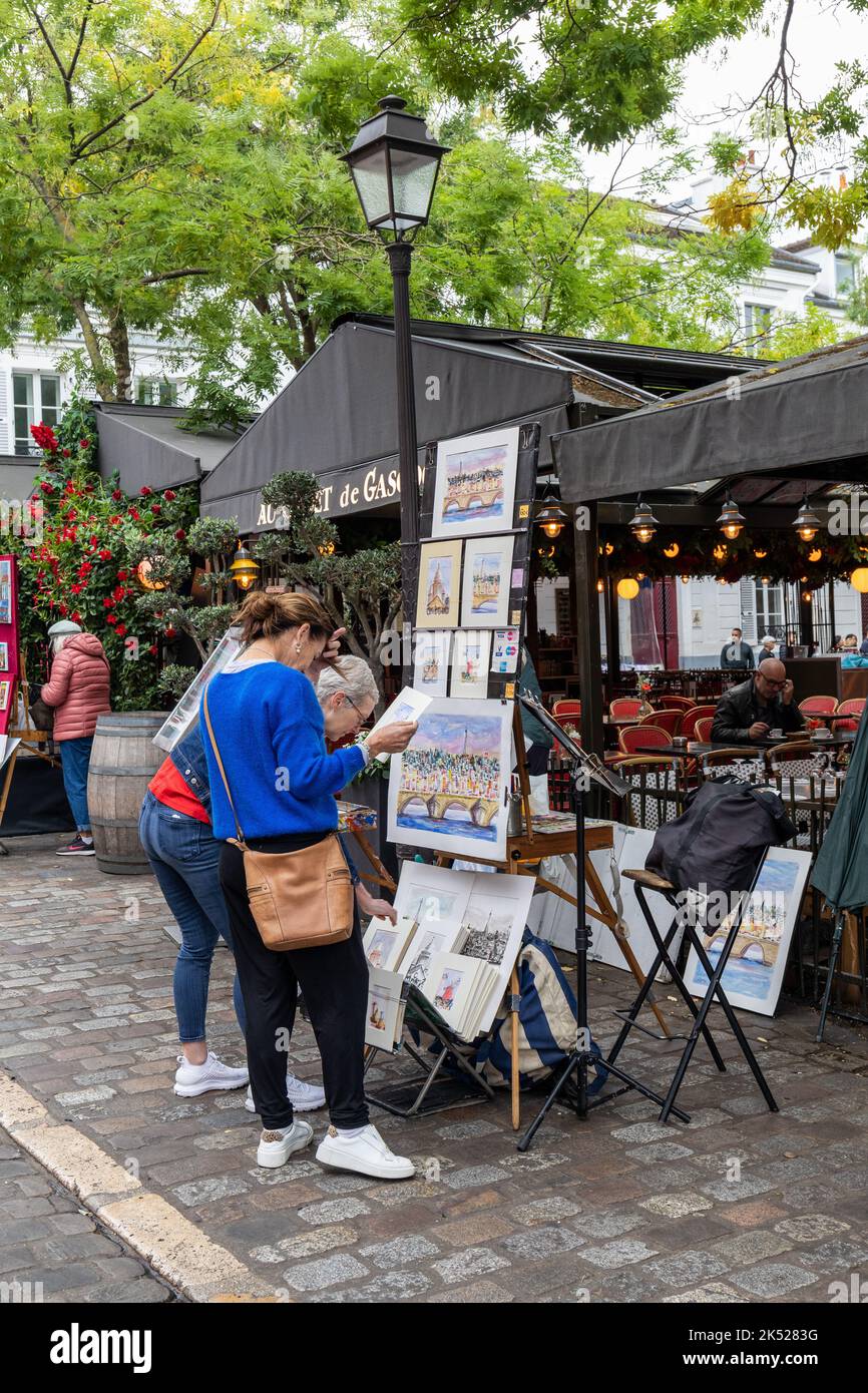 Tourists looking to buy artwork in Tertre square in Montmartre, Paris. It is famous as an artistic centre for painters, Montmartre, Paris, Europe Stock Photo