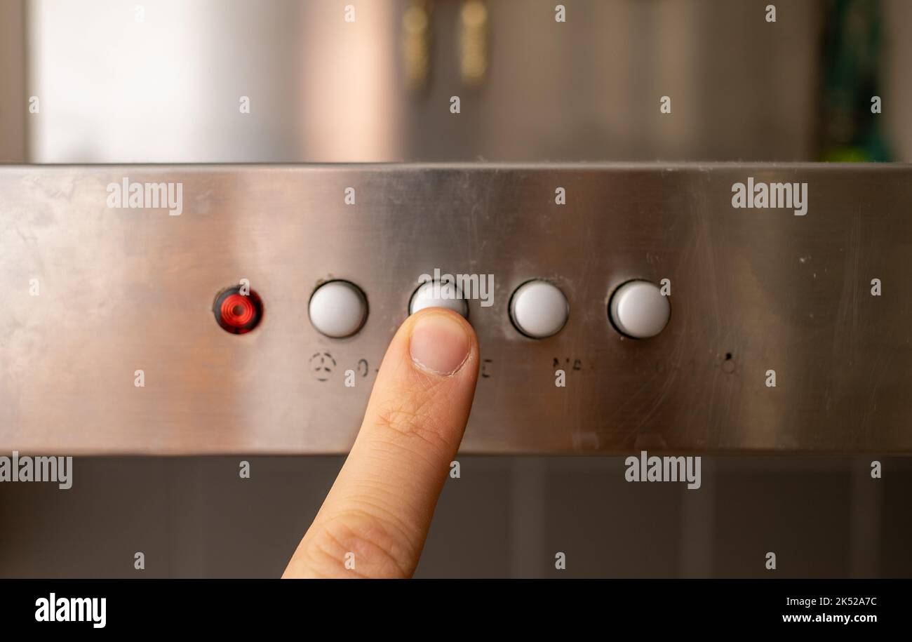 man finger pressing button on dirty metal panel Stock Photo
