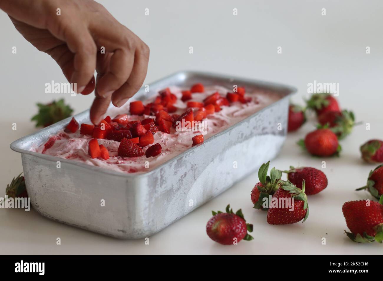 Homemade strawberry ice cream taken out from freezer in a loaf tin