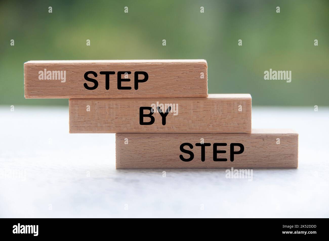 Step by step text on wooden blocks with blurred nature background Stock Photo