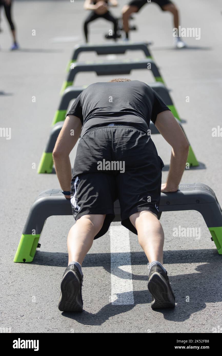 People doing sports in the street with jumps, races, weights and on