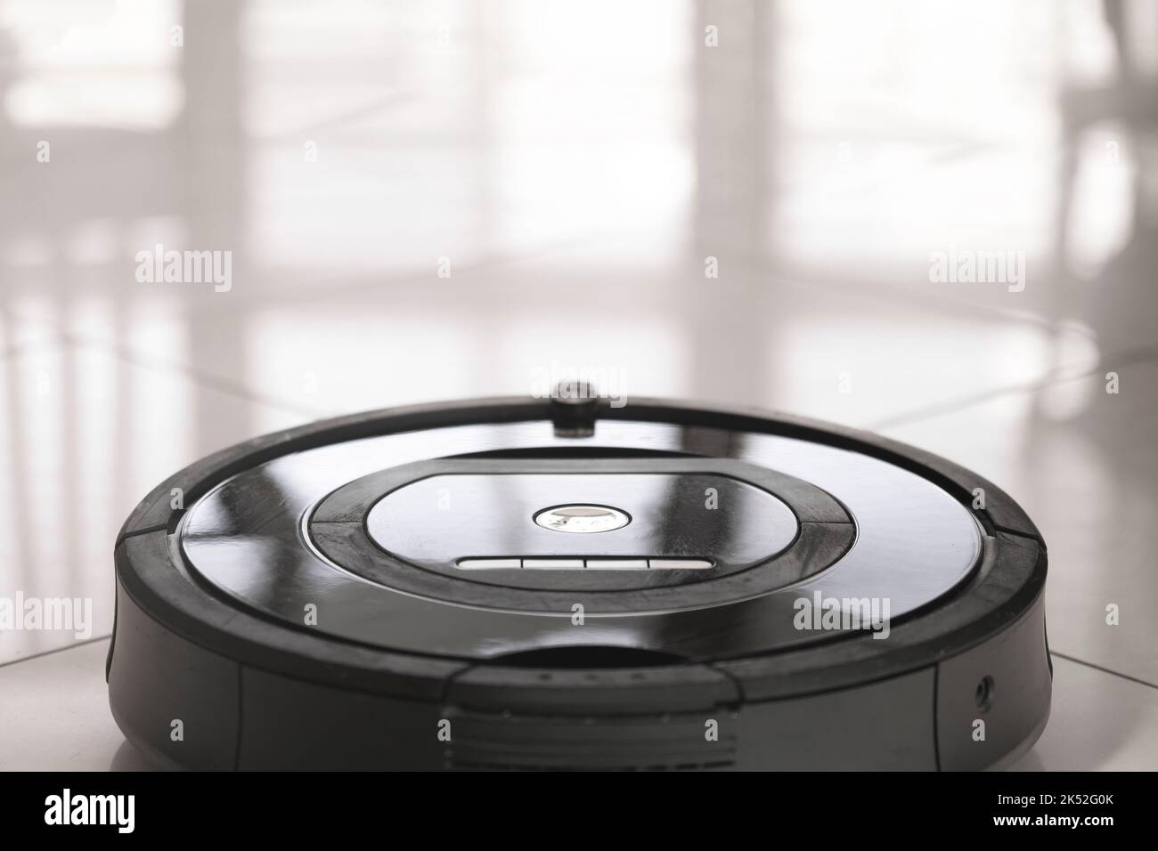 Robot vacuum cleaner on a tiled floor close-up Stock Photo