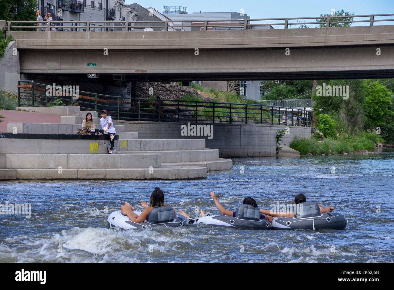 Three friends float down the South Platte River on a hot day on