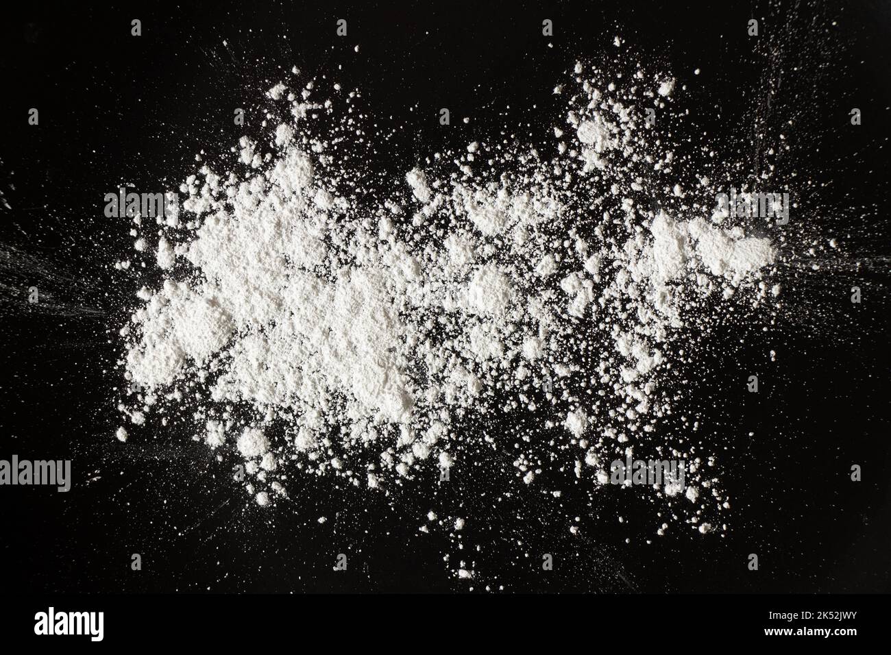 white powder on black background, flour sprinkled for background Stock Photo