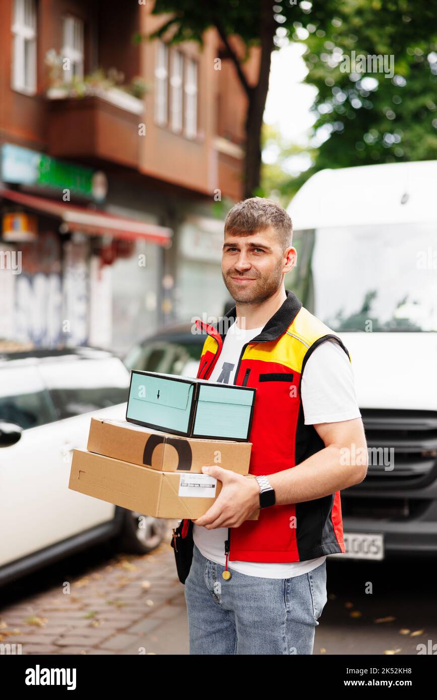 Portrait of the worker , courier at work in front of his van on the street Stock Photo