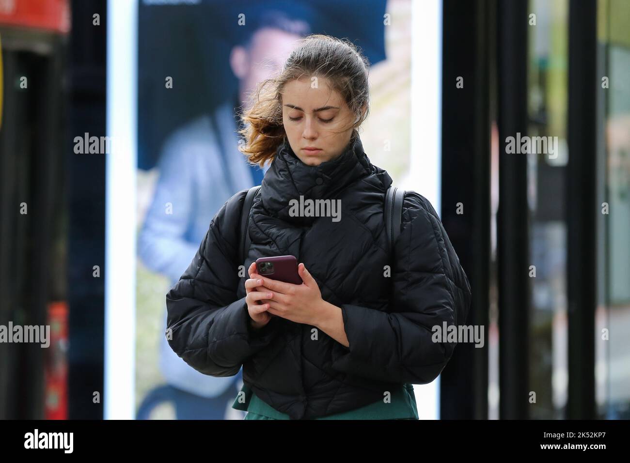 A woman seen using her mobile phone while walking outside Warren Street ...