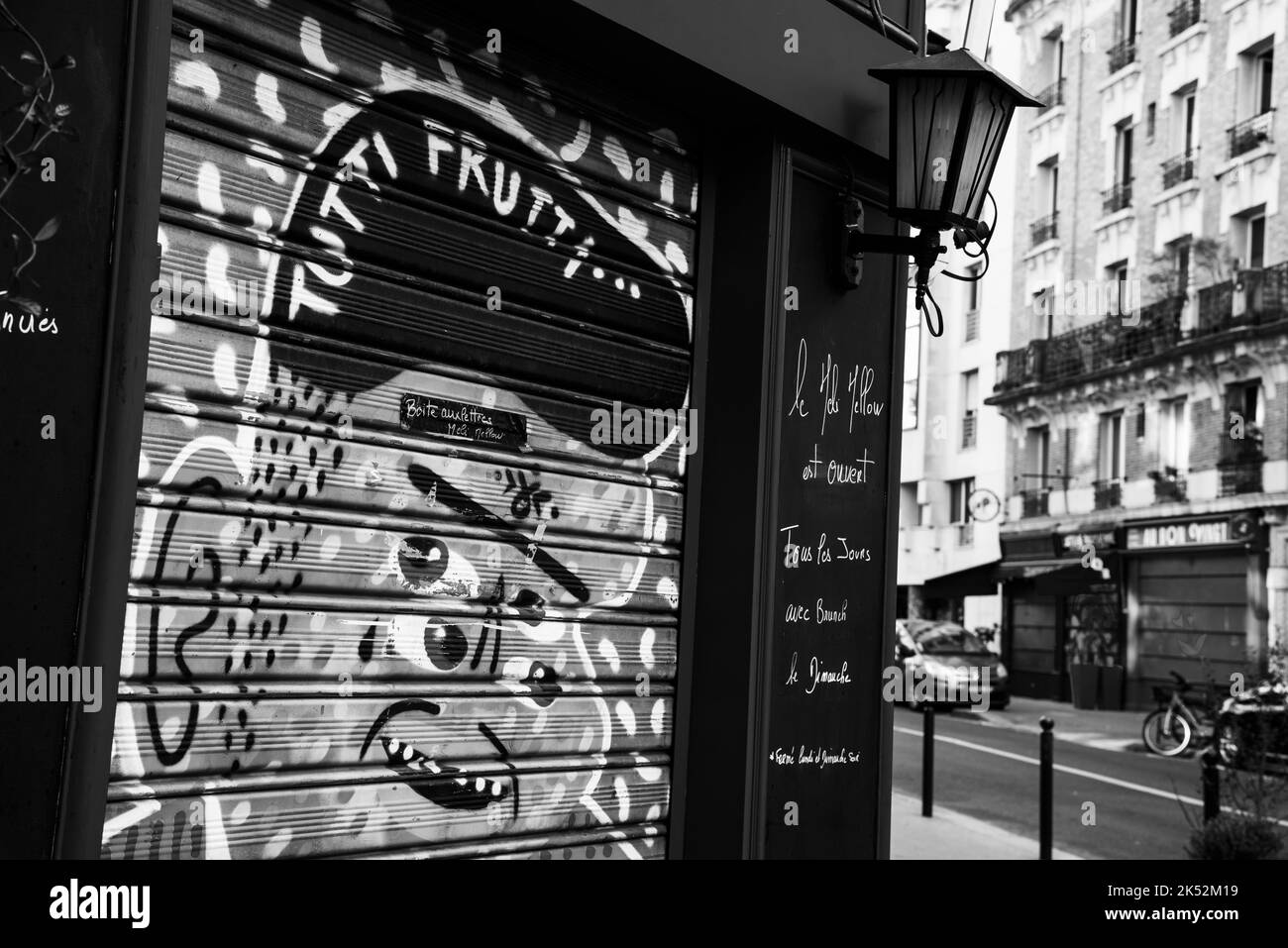 Paris, France - November 1, 2021: Exterior of Parisian restaurant Meli Mellow Bagnolet street with funny graffiti. Black white historic photo Stock Photo