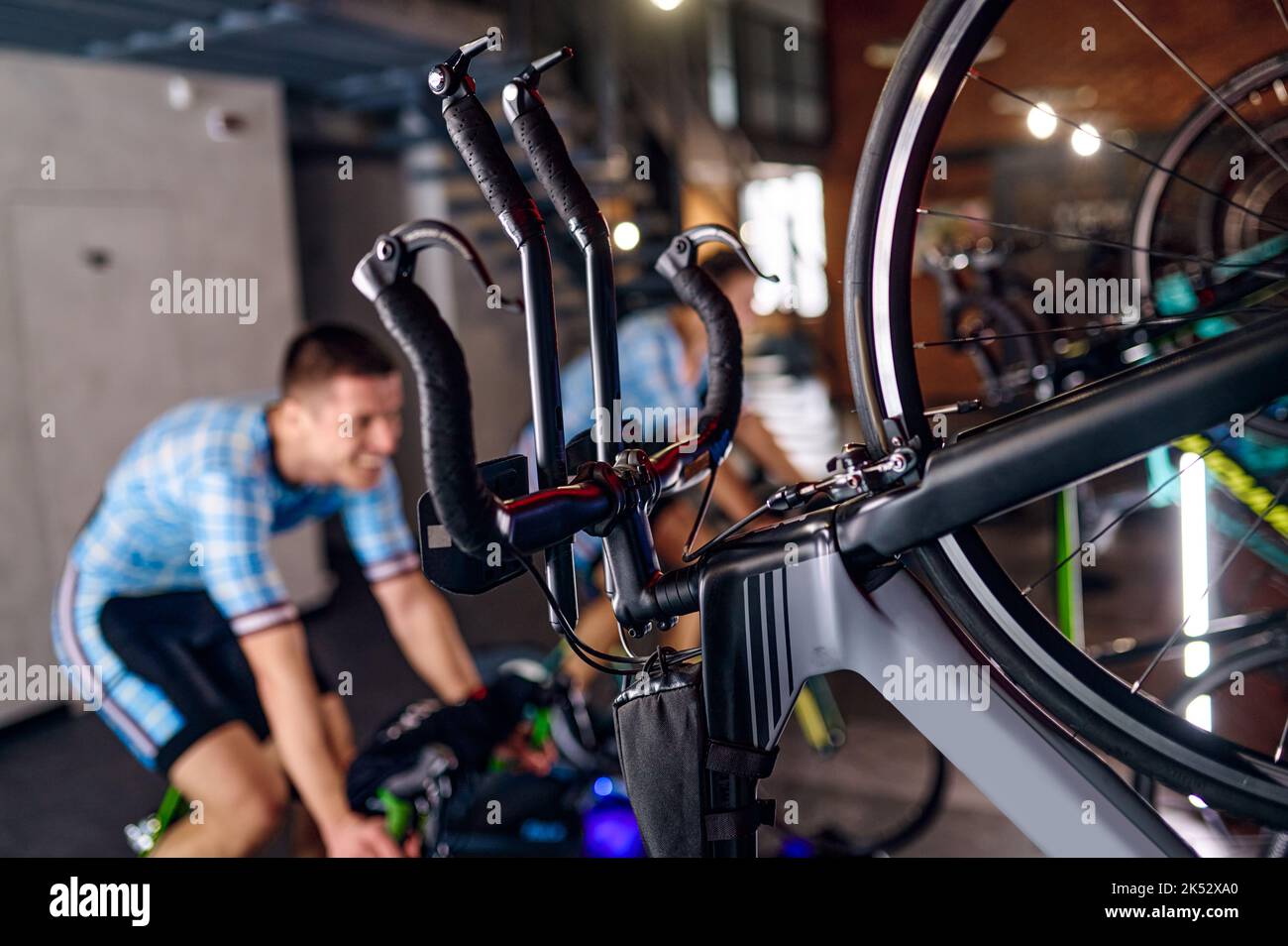 Bicycle riding exercise at gym class, view from bicycle handlebar Stock