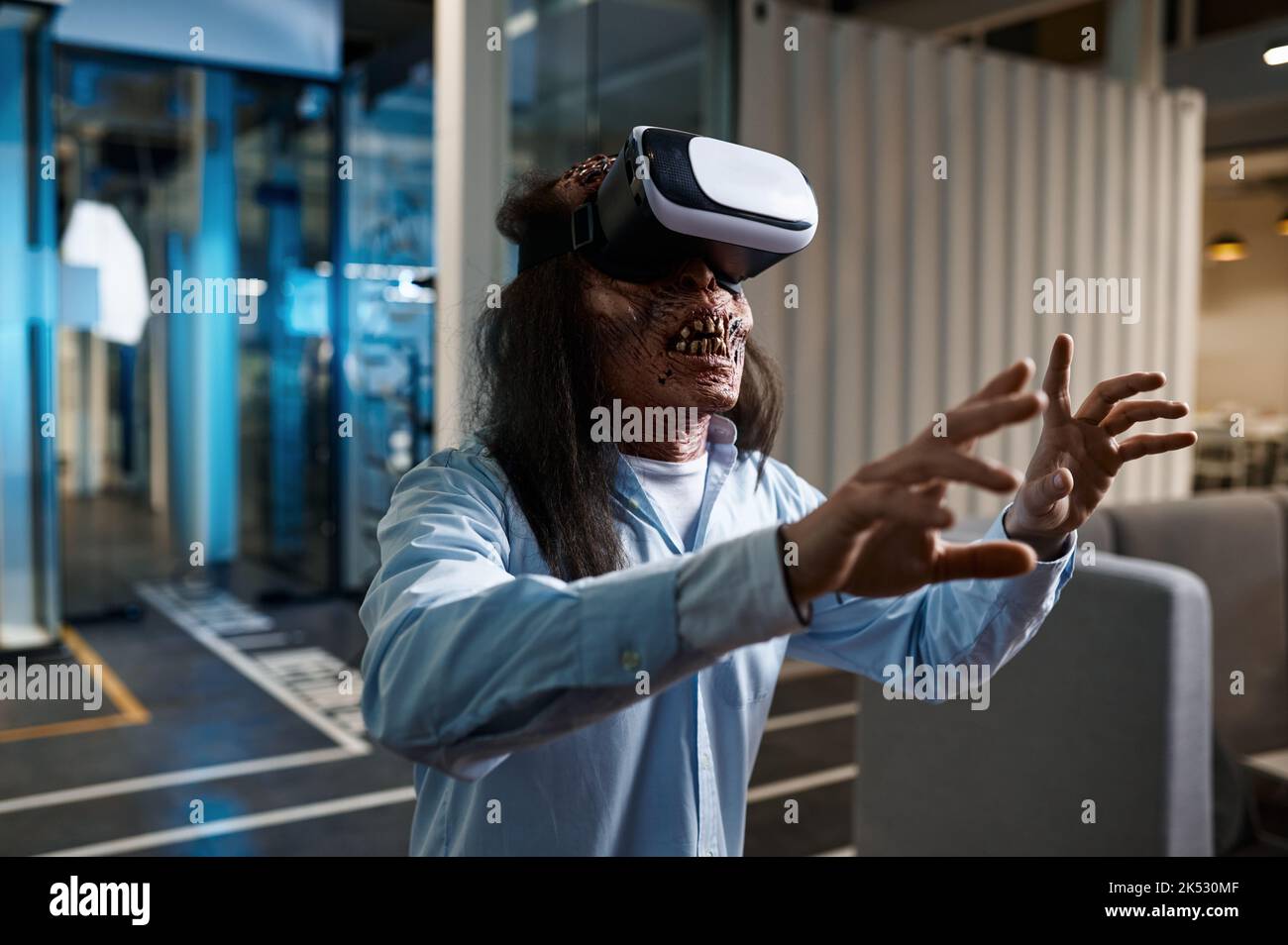 Zombie office worker using VR simulator headset Stock Photo
