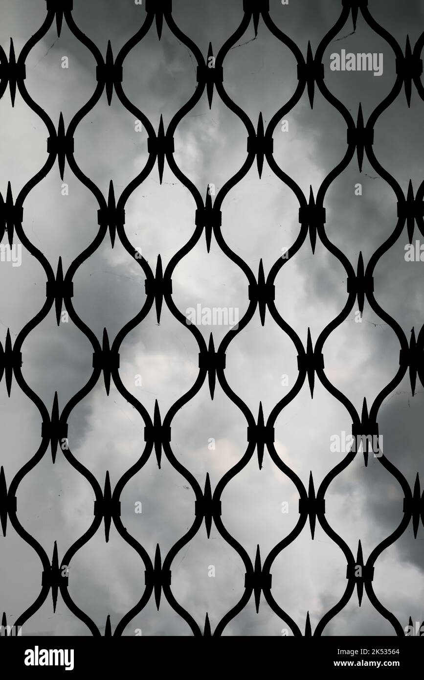 Forged iron gates against the gray sky. An iron door grid background Stock Photo