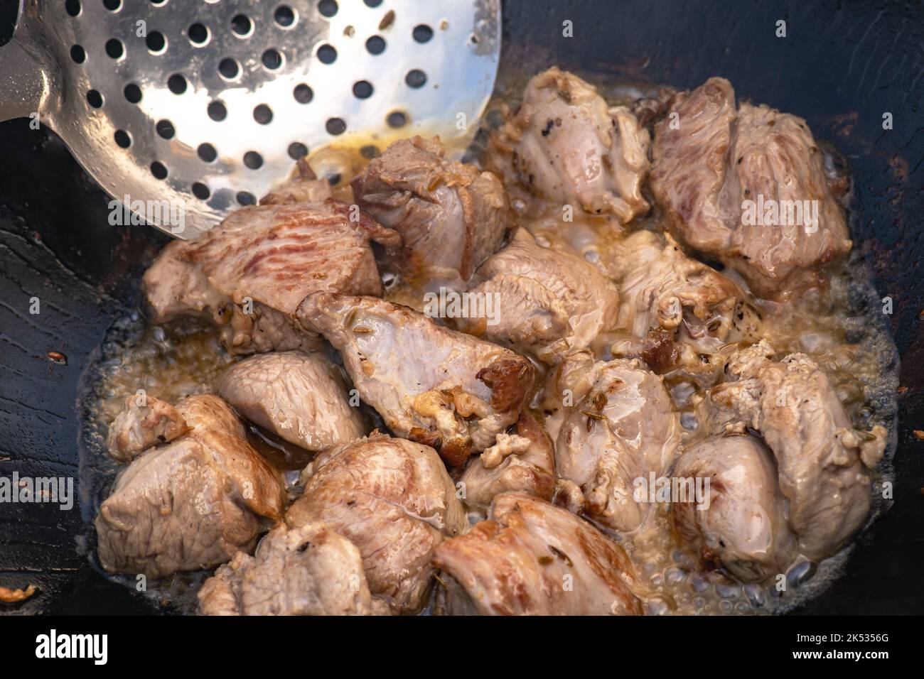 https://c8.alamy.com/comp/2K5356G/large-chunks-of-lamb-sheep-fried-in-oil-with-bubbles-in-a-black-cauldron-close-up-cooking-food-2K5356G.jpg