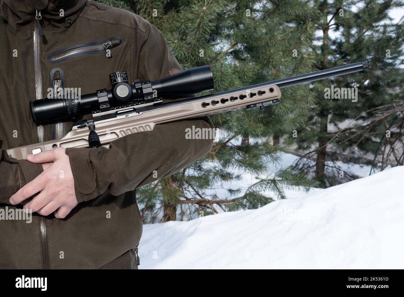 A sniper rifle with an optical sight in man`s hands soldier winter day ...