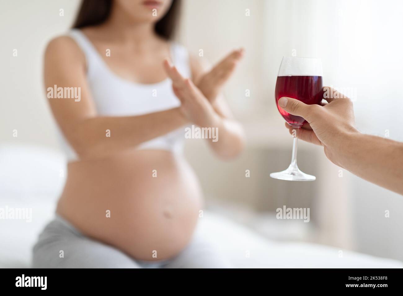 Unrecognizable pregnant woman refuses to drink wine, cropped Stock
