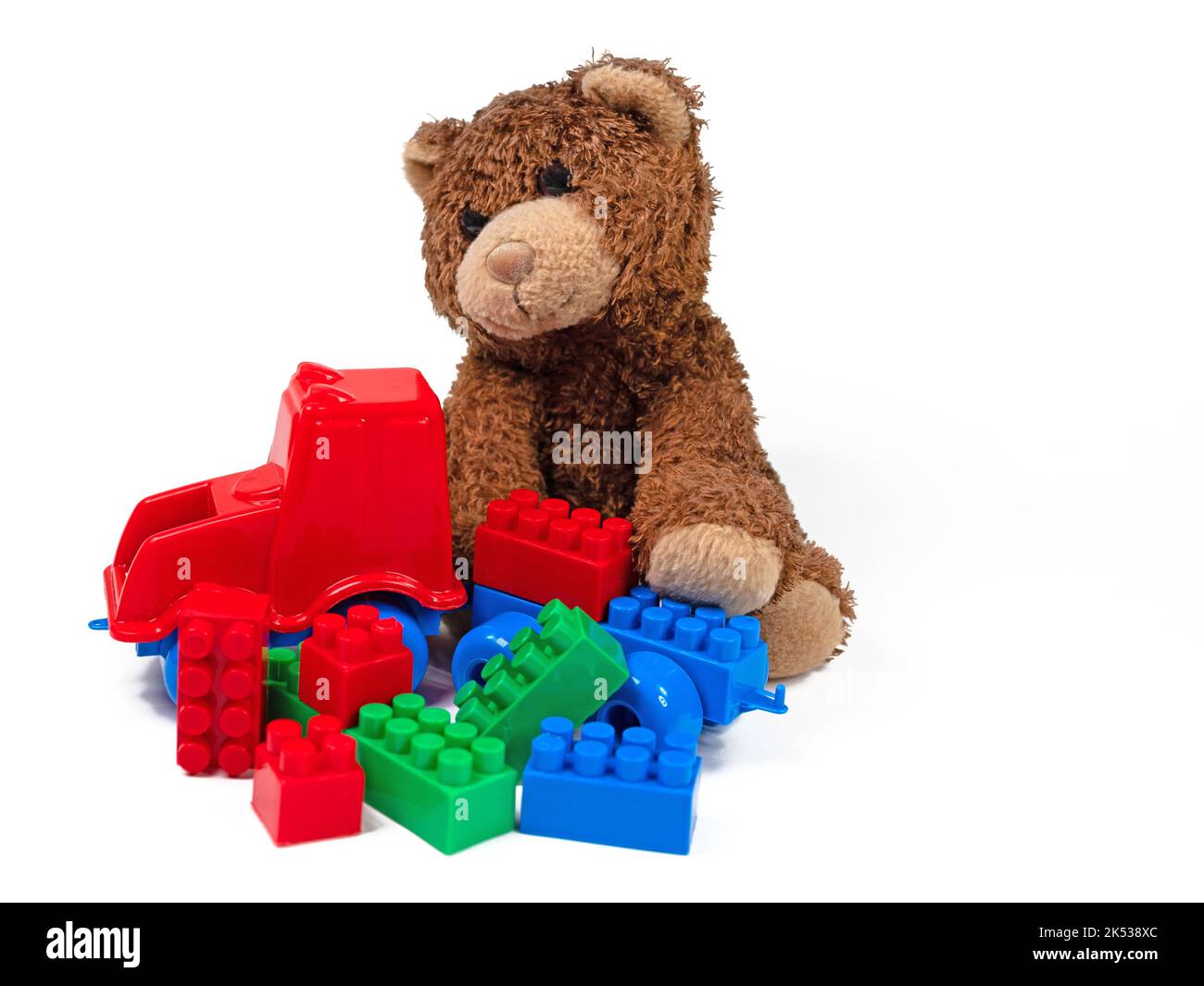 Plush bear and plastic building blocks against a white background Stock Photo