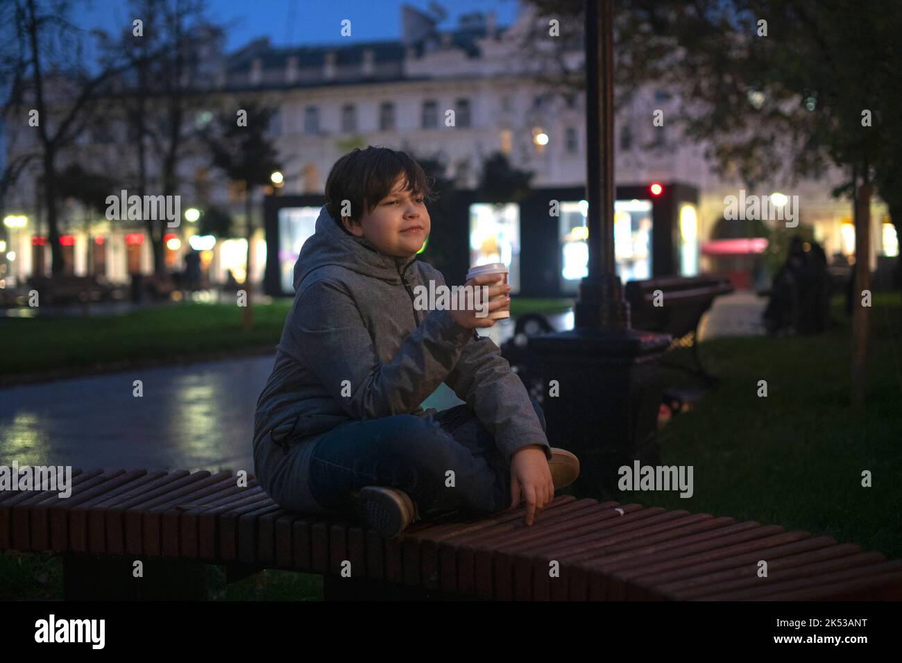 A teenager with positive emotions and a paper cup in his hand on the ...