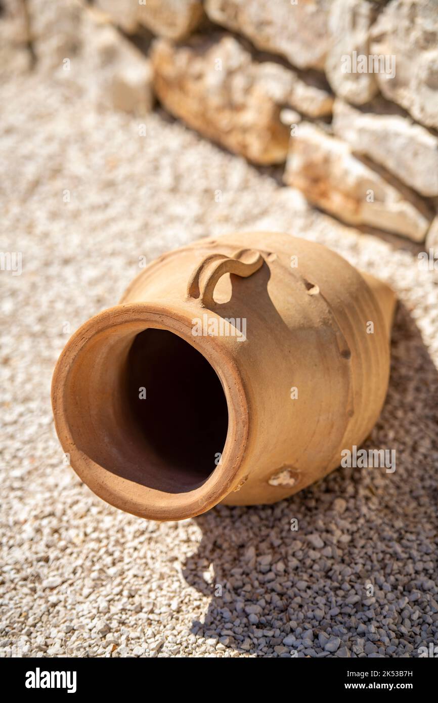 traditional greek old terracotta olive jar lying on its side on some stones Stock Photo Alamy
