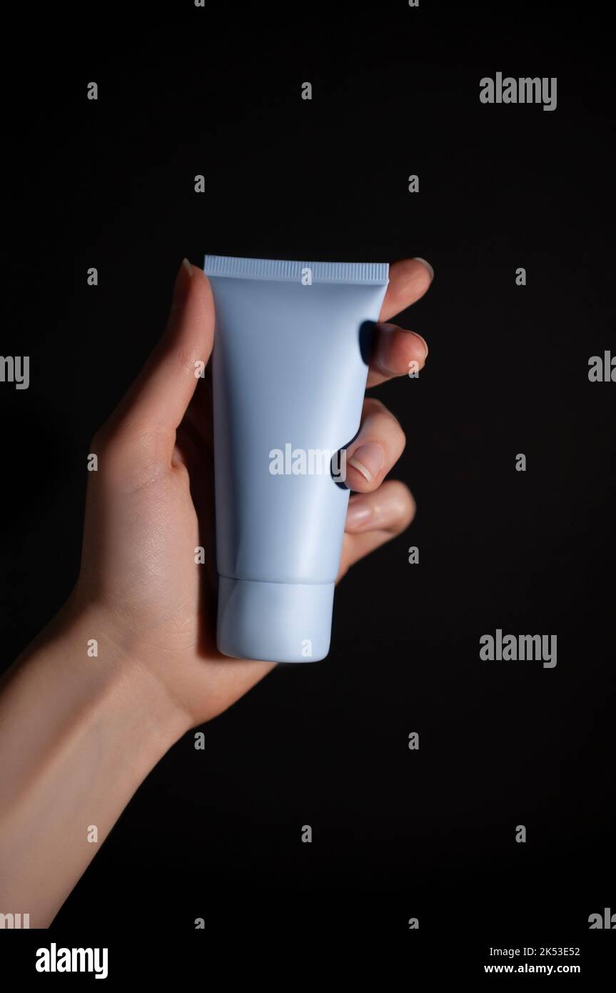 Hand and face care. Concentrated cosmetic. Dark background. Stock Photo