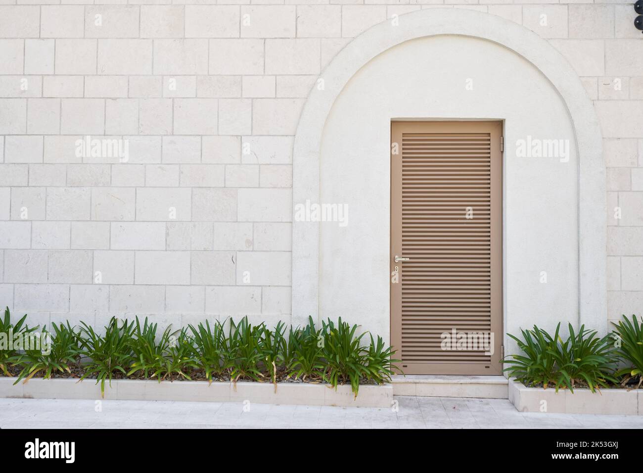 louvered plastic door on the stone wall. Stock Photo