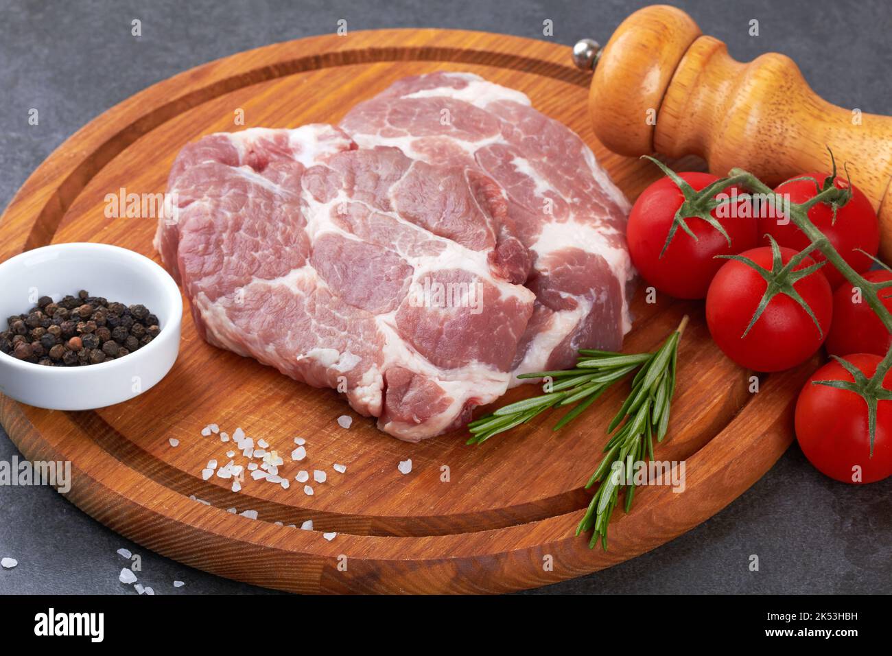 Raw meat with tomatoes on a black surface Stock Photo