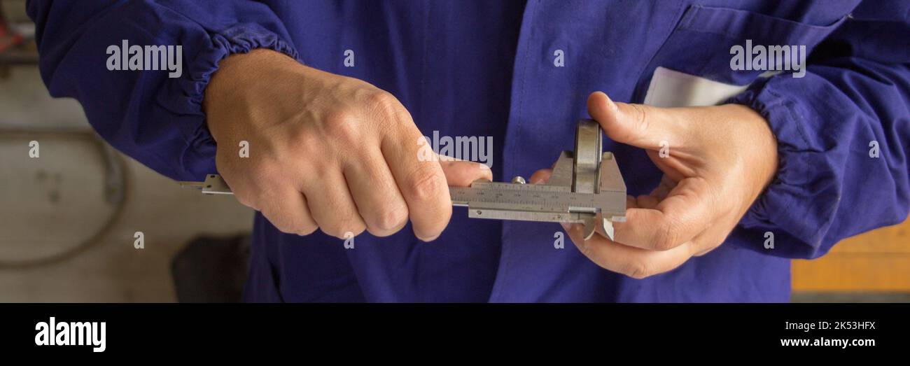Image of the hands of a mechanic measuring a ball bearing with a