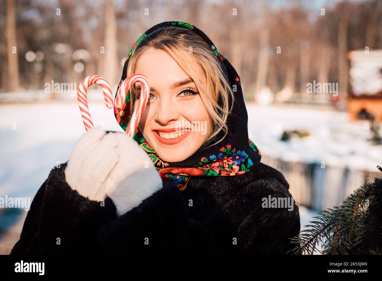 A young beautiful woman in a national Slavic headscarf with lollipops Stock Photo