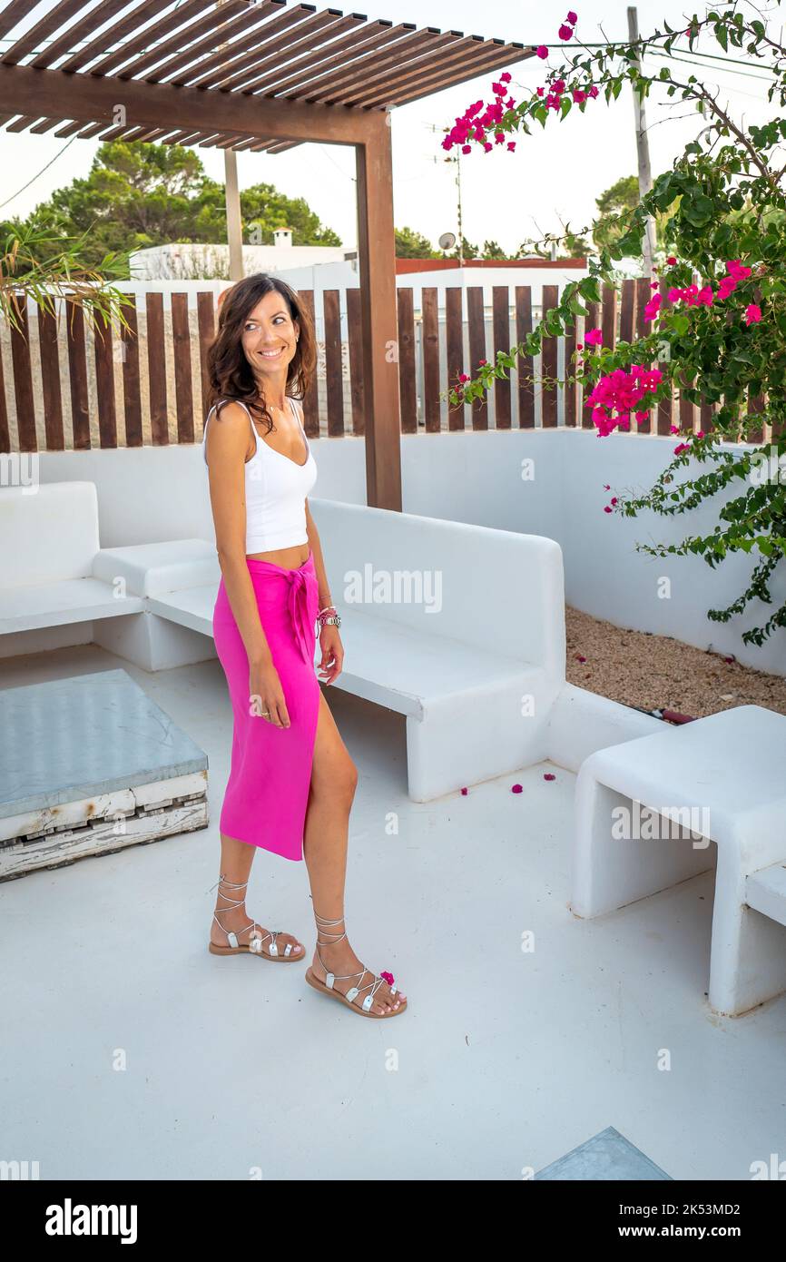 Brunette woman with pink skirt posing in a boutique hotel Stock Photo