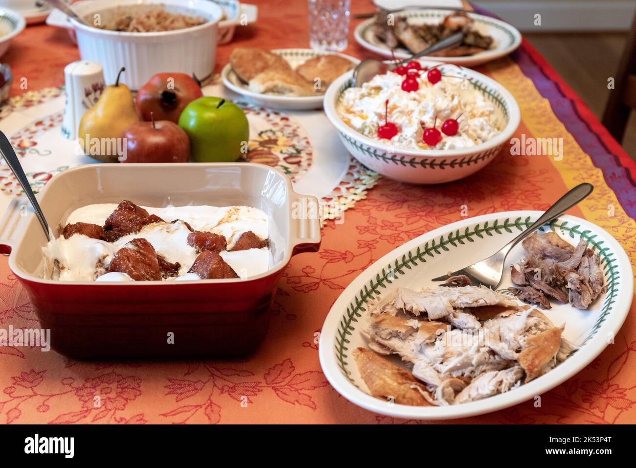 Closeup View of Thanksgiving Dinner Table with Turkey, Candied Yams and Fruit Salad Stock Photo