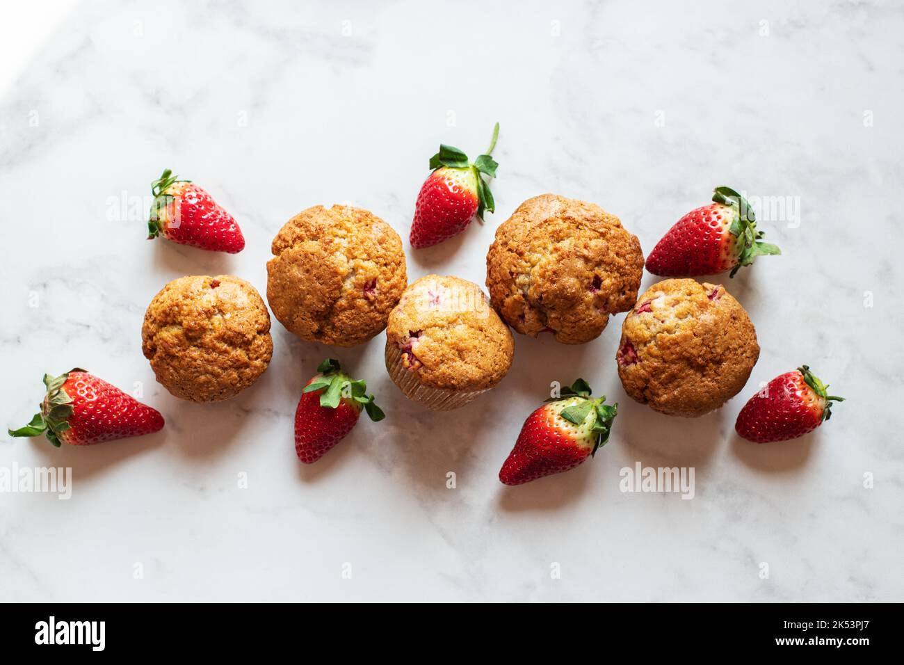 Strawberry muffins on a marble background. Top view. Stock Photo