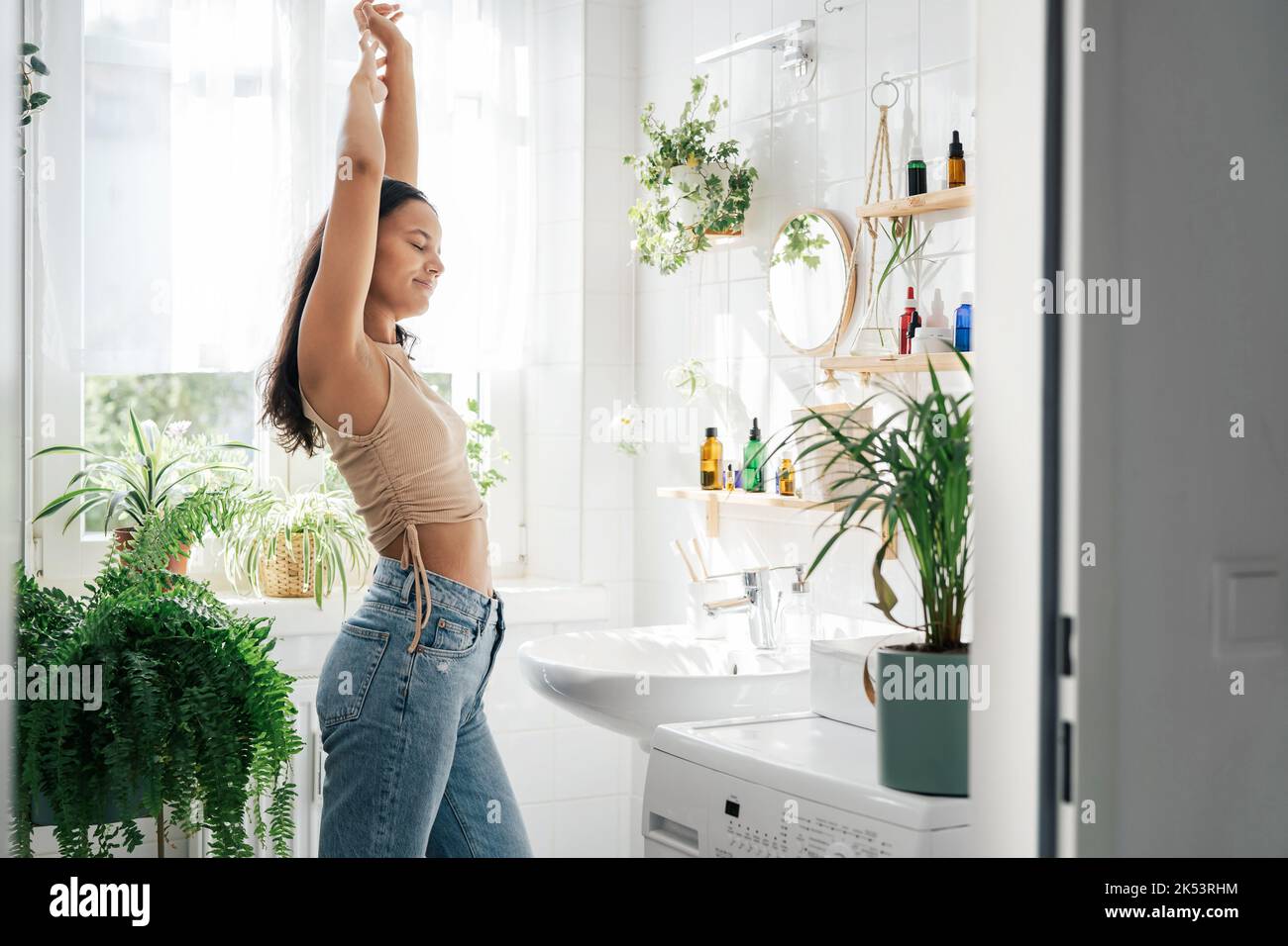 Young woman stretching in bathroom. Body positivity, confort home zone ...
